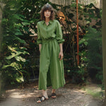 Woman in the Foliage Green linen shirt dress by Linen Tales, standing in a leafy garden