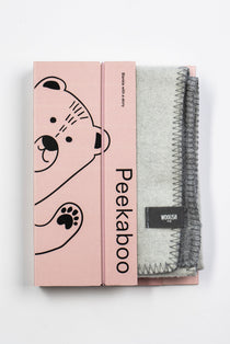 Pink Peekaboo gift box beside the folded grey Teddy merino baby blanket by Woolish