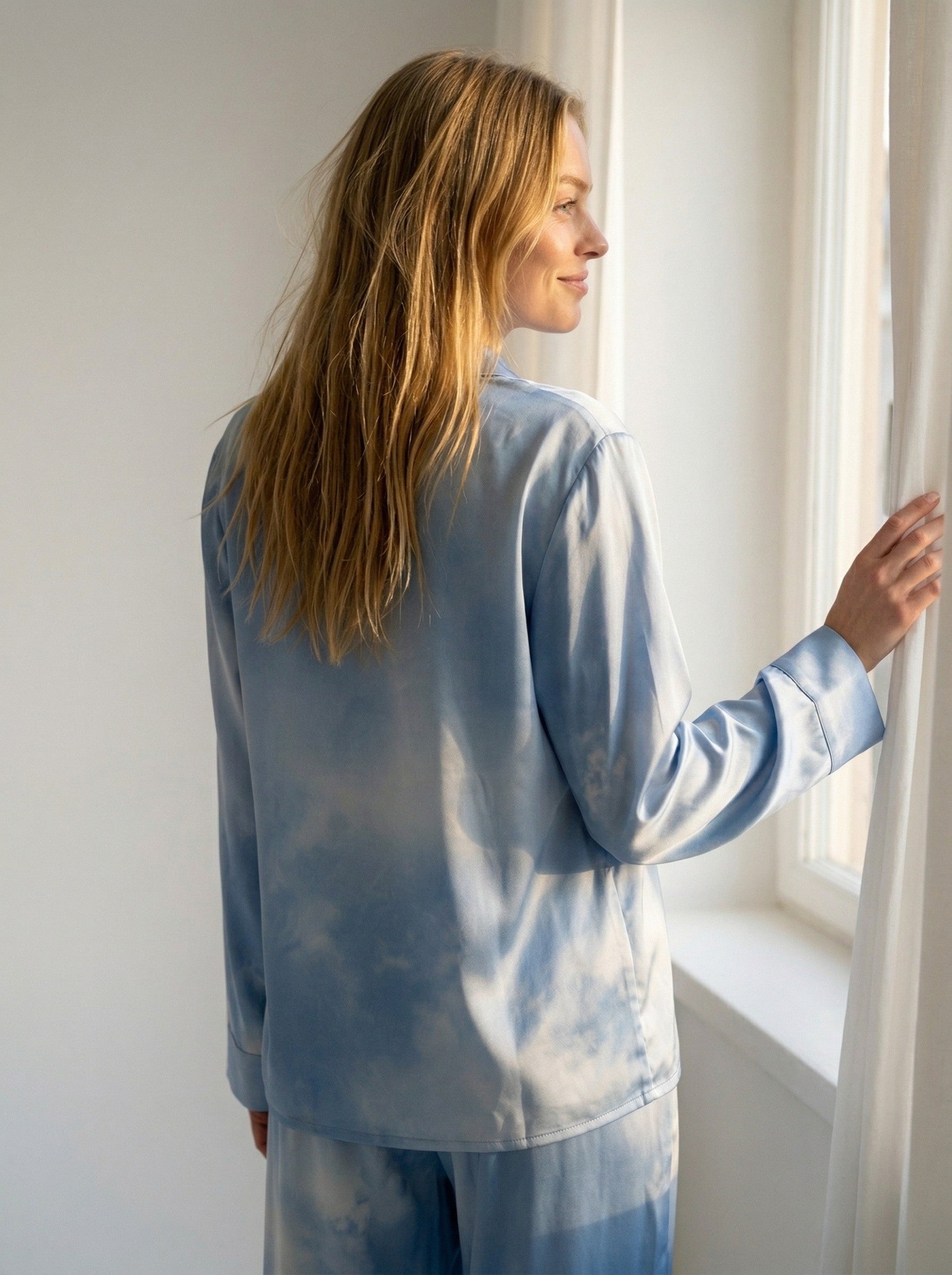 Tæwas Blue Sky sidenpyjamas från sidan, med Tanel Veenres himmels- och molnmönster på ärmen