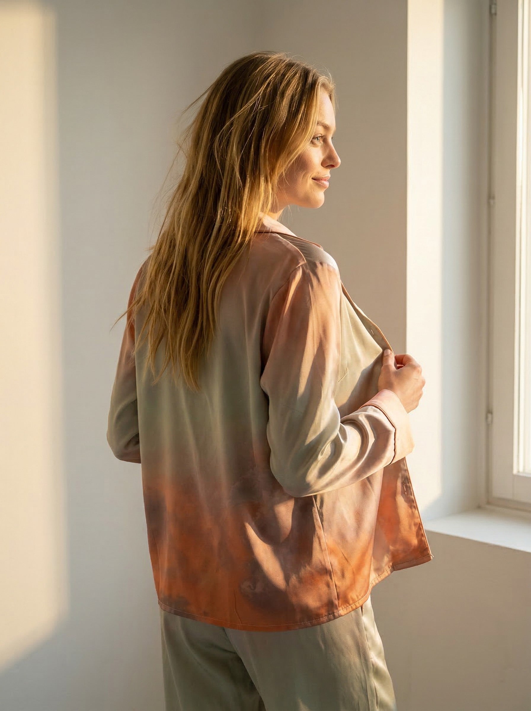 Side view of the Tæwas Sunset silk pyjama shirt, print shading from lilac to coral